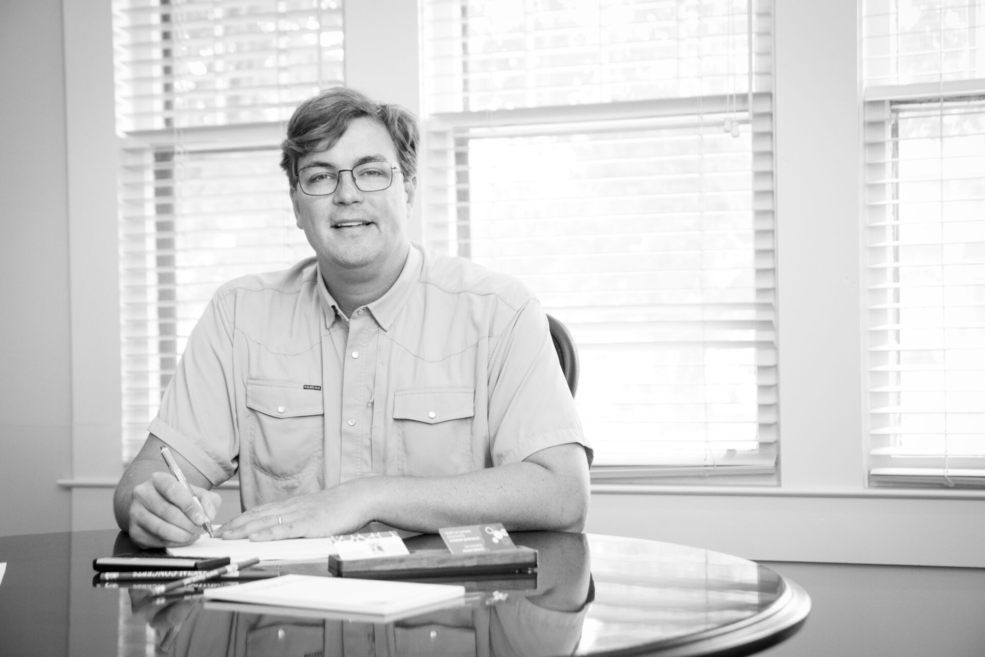 man signing document and sitting on the chair